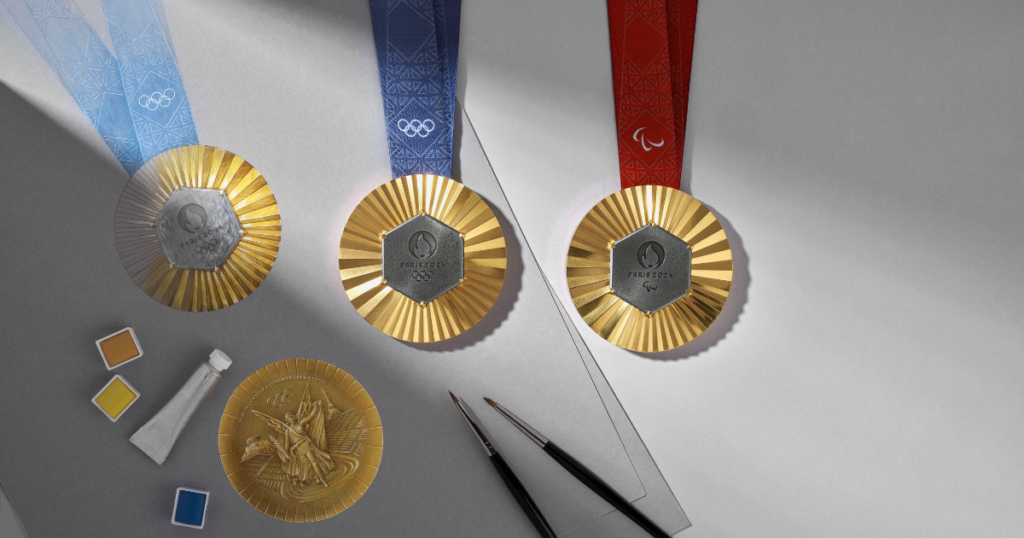 Bronze, silver and gold olympic medals alongside artist tools including paint and paint brushes